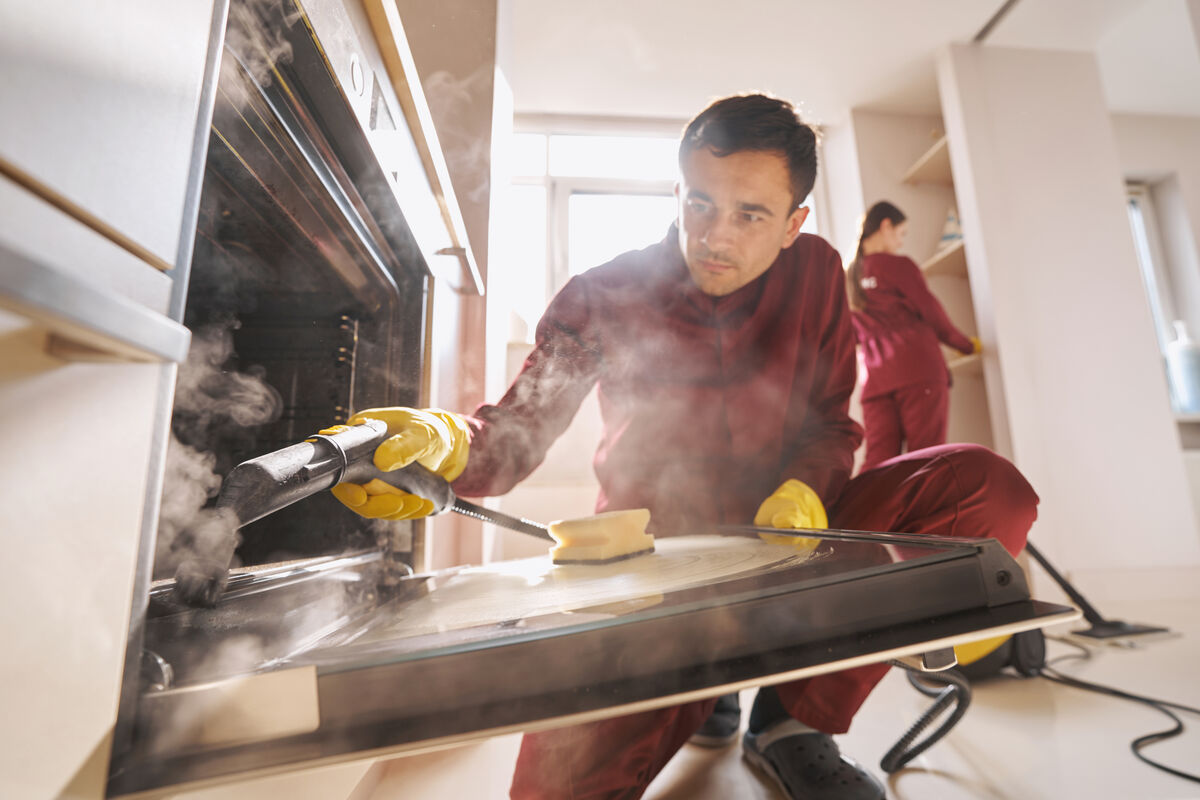 A cleaning technician working in a commercial kitchen